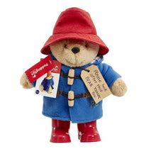 Load image into Gallery viewer, As a standing 25cm plush character, the Classic Paddington with Boots is an iconic addition to any Paddington Bear collection and is the perfect playroom pal to accompany story time for children aged 10 months and over. This striking soft and cuddly character toy features the distinctive and famous Paddington Bear accessories including a super soft lined duffle coat with real toggles, a battered red felt bush hat and &#39;real&#39; shiny red wellington boots
